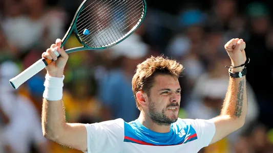 Stan Wawrinka lifts his racket in celebration after beating first-round rival Damir Dzumhur in the Australian Open at Melbourne Park on Tuesday.